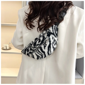 Detail of zebra print faux fur waist bag featuring dual metal zippers and nylon strap