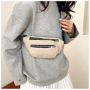 Close-up of beige fleece waist bag with dual black zippers and adjustable strap