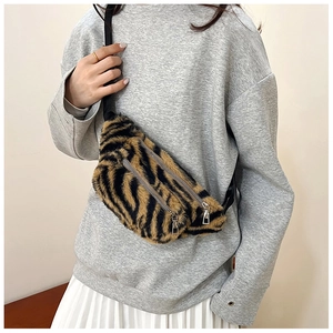 Detail of plush tiger print waist bag with dual metal zippers and soft faux fur texture