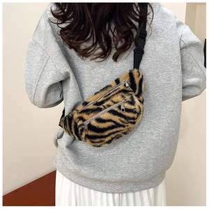 Detail of faux fur waist bag with yellow tiger pattern and dual metal zipper compartments