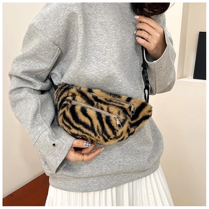 Detail of tiger pattern plush crossbody bag showing soft faux fur and dual silver zippers