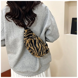 Detail of tiger print faux fur chest bag showing dual zippers and adjustable strap