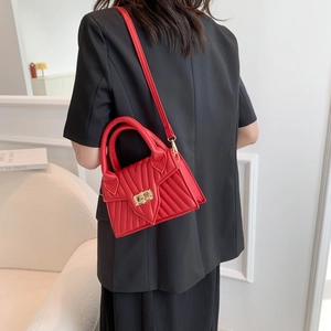 Red quilted leather crossbody bag with V-shaped stitching and golden twist lock closure