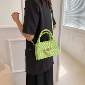 Neon green quilted shoulder bag with V-pattern stitching and golden metal twist lock