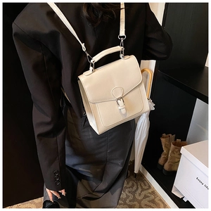 Detailed view of beige PU leather square backpack with adjustable straps and silver hardware