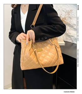 Close-up of khaki quilted tote bag with gold chain strap and stylish FASHION logo detail