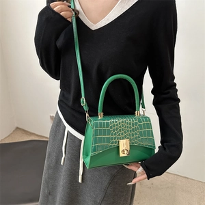 Green faux leather crossbody bag with crocodile pattern and golden turn-lock closure