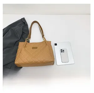 Detail of khaki quilted tote bag showing large capacity and fashion metal logo plaque