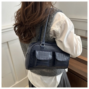 Detail of dark blue crocodile pattern underarm bag with double utility front pockets