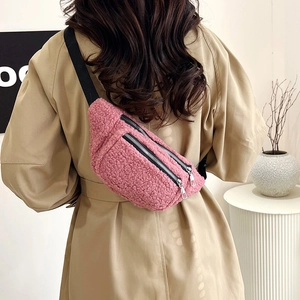 Rosafarbene Bauchtasche aus Teddyvlies mit Doppelreißverschluss an beige Mantel