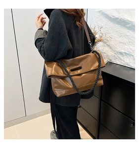 Dettaglio di una borsa tote in pelle PU marrone con tracolla in corda nera intrecciata