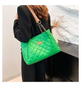 Detail of bright green quilted shoulder bag with gold chain strap and fashion label