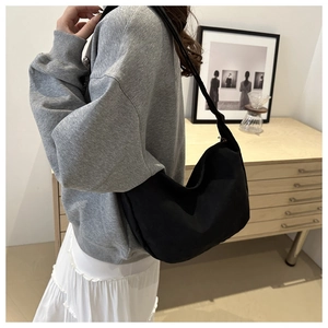 Vista dettagliata della borsa a mezzaluna nera indossata da una modella casual