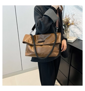 Dettaglio borsa shopper marrone con manico intrecciato nero e tracolla in nylon regolabile