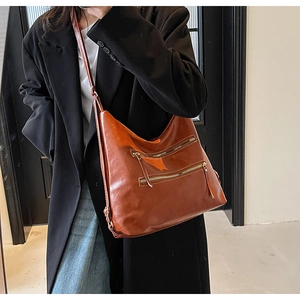 Détail du sac hobo rétro caramel avec double fermeture éclair et texture cuir huilé