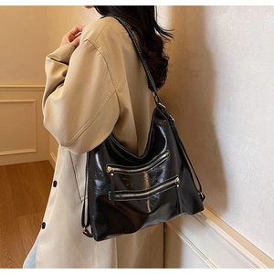 Détail du sac cabas en cuir noir brillant avec trois fermetures éclair et grande capacité
