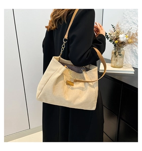 Détail du sac cabas en velours côtelé beige avec texture et sangle en cuir marron