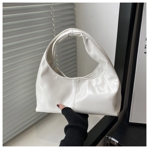 Close-up of white glossy leather Hobo shoulder bag with elegant stitching details