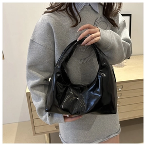 Close-up of shiny black leather hobo bag with a minimalist design and soft glossy texture