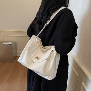 Creamy white tote bag with glossy finish and gold chain strap in minimalist style