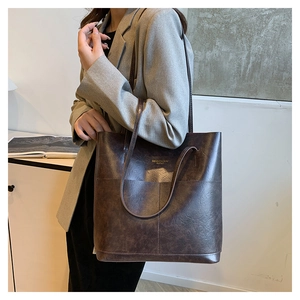 Nahaufnahme der dunkelbraunen Retro-Einkaufstasche mit eleganter goldener Beschriftung