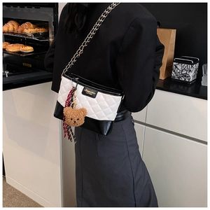 Sac à bandoulière matelassé chic porté par un mannequin dans un décor de cuisine stylé