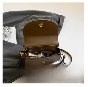 Interior view of brown saddle bag showing gold hardware and spacious main compartment