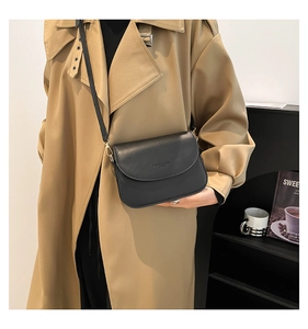 Minimalist black PU leather crossbody bag worn with a stylish khaki trench coat