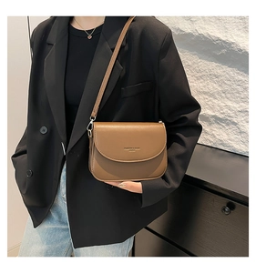 Close-up of brown leather crossbody bag with Fashion & Bags lettering on minimalist flap