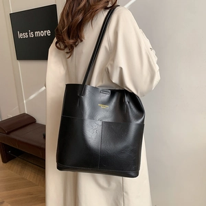 Minimalistische schwarze Tragetasche mit Litschi-Textur und goldenem Logo
