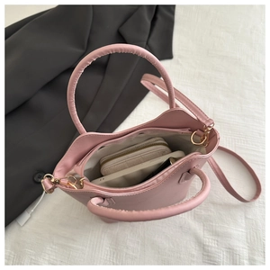 Top view of pink bucket bag interior showing capacity for phone and zipper wallet