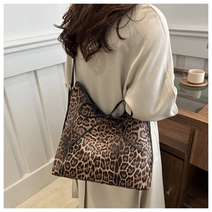 Detail view of large leopard print tote bag with decorative black bow on the shoulder