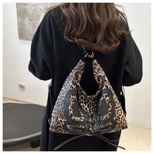 Detailed view of leopard print tote bag with black leather butterfly and lacing details