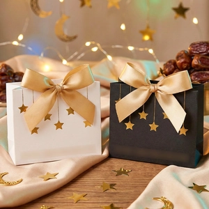 Geschenktüten in Schwarz und Weiß mit goldenen Sternmustern und Satin-Schleifenband