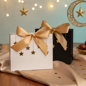 Detail von Luxus-Geschenktüten mit Goldsternfolie und Satinschleifen auf Seide