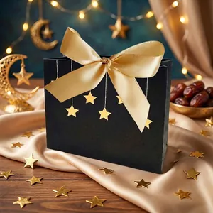 Detail der schwarzen Geschenktüte mit goldenen Sternen und einer breiten Schleife