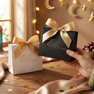 Elegant Eid Mubarak gift bags in black and white with golden satin bows for party favors