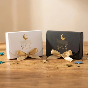 Elegant black and white gift boxes with gold foil star and moon patterns and satin bows