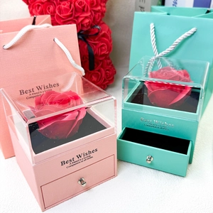 Gros plan de boîtes cadeaux de roses rose et vert menthe avec couvercle en acrylique