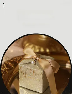 Detail of champagne gold wedding favor box with glitter finish and satin ribbon bow