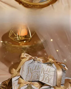 Detail view of silver glitter wedding candy box with golden bow and pearl charm pendant