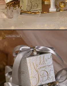 Detail of glitter wedding favor box with pearl pendant and elegant satin bow