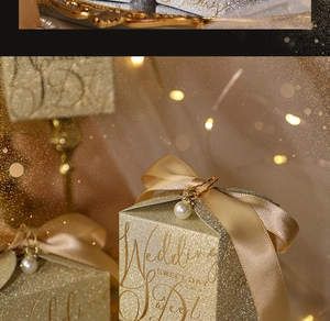 Detail of square gold glitter wedding gift box with satin bow and pearl pendant