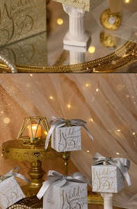 Detail of silver glitter wedding favor box with grey ribbon, pearl and gold charm