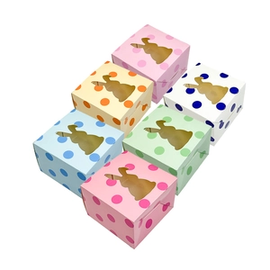 Close-up of colorful Easter gift boxes with polka dots and rabbit-shaped window cutouts