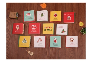 Detail of 12 creative Christmas mini cards set with envelopes on warm wood background