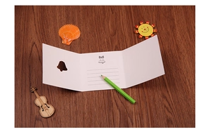 Detail of creative Christmas card with bell cutout, writing lines and green pencil