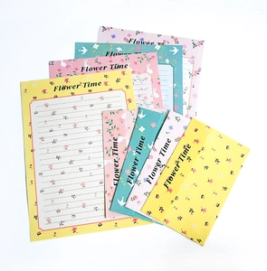 Detailed flat lay of floral stationery set with pastel envelopes and cute animal patterns