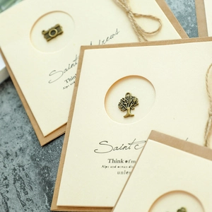 Vintage bronze alloy pendant on beige cardstock with jute string and kraft paper base