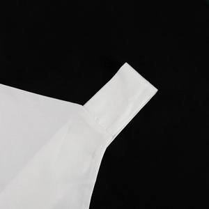Nahaufnahme der feinen Nähte und Textur am Träger des weißen Satin-Neckholder-Kleides